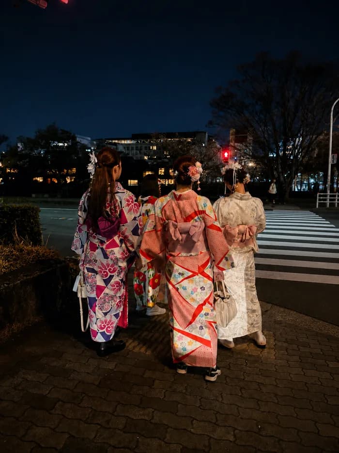 A loose photo print of two people in kimono walking through Kyoto in the evening