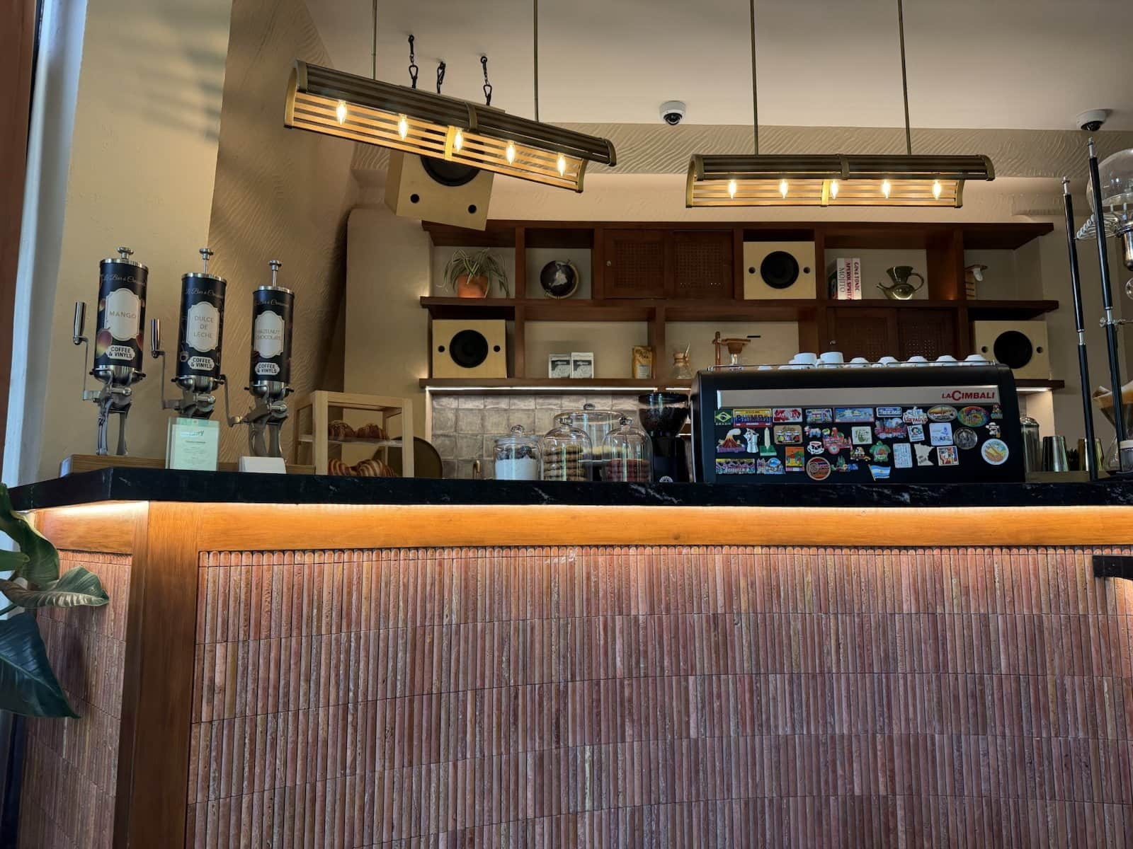 The Coffee & Vinyls bar with warm under-counter lighting, coffee equipment and shelves behind