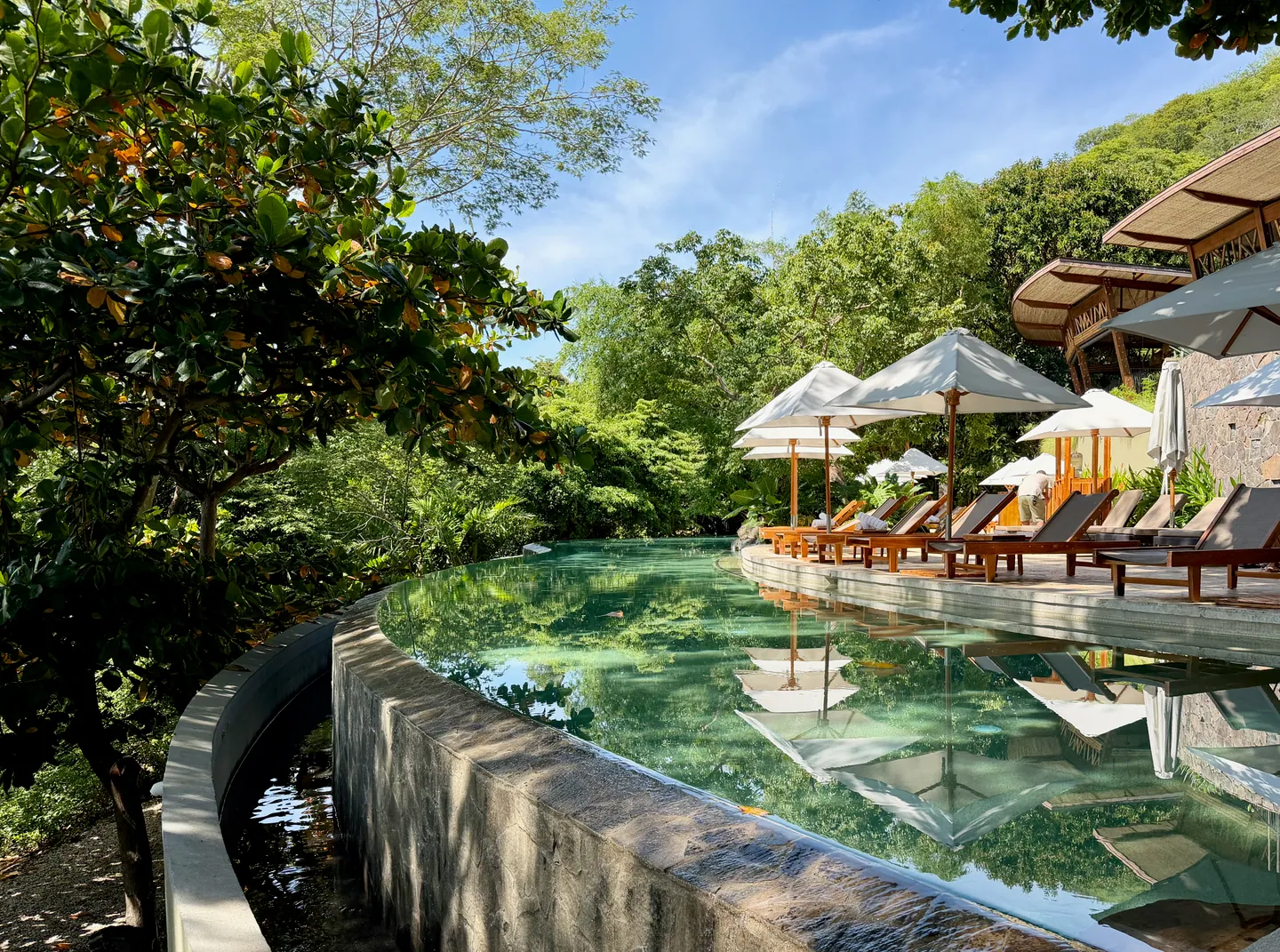 A resort pool with white parasols among the trees, Papagayo Peninsula, Costa Rica